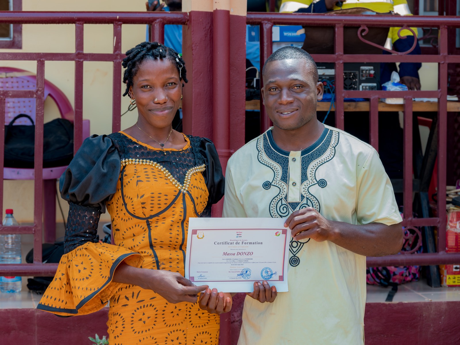 A graduate receives her training certificate in Beyla