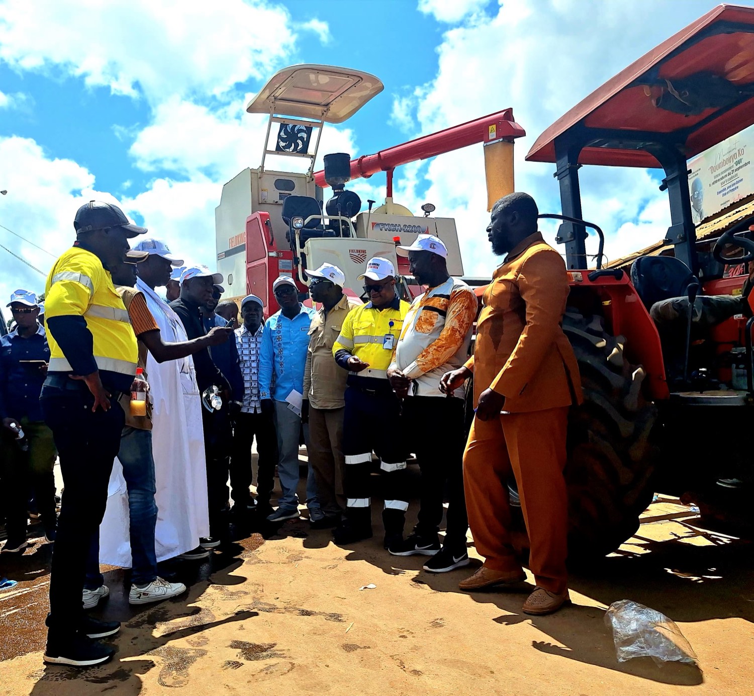 SimFer and community representatives with the combine harvester donated to rice farming groups